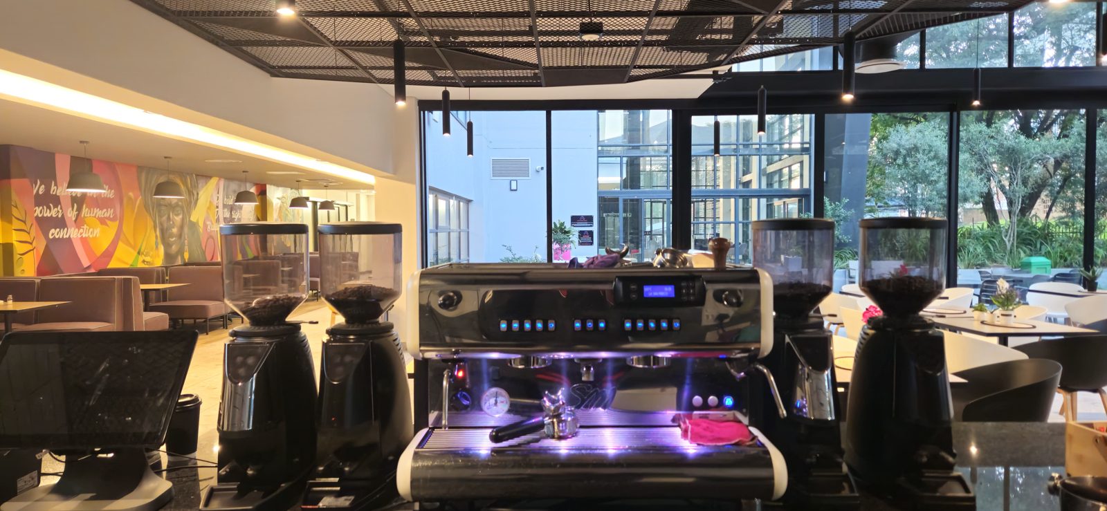The espresso machine and grinders on the coffee shop counter