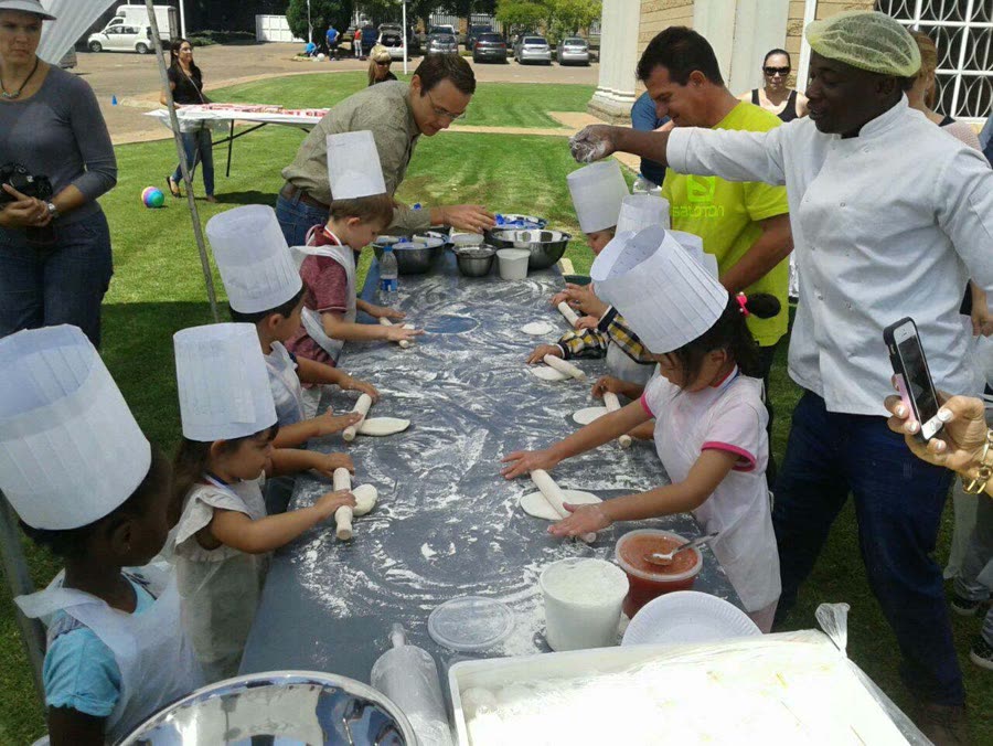 Children making pizzas at a school event